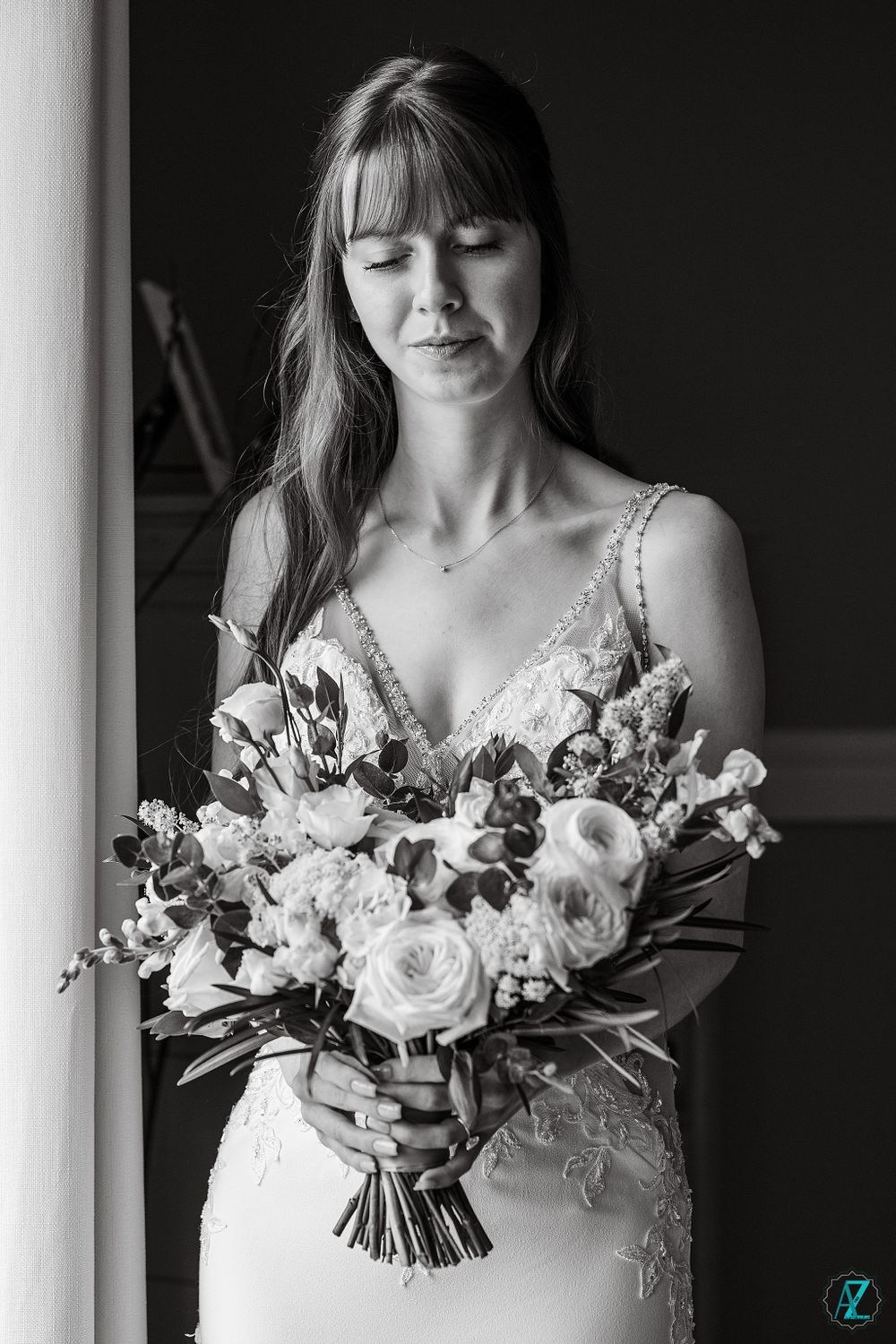 A dramatic black and white bridal portrait with a stunning white rose bouquet.
