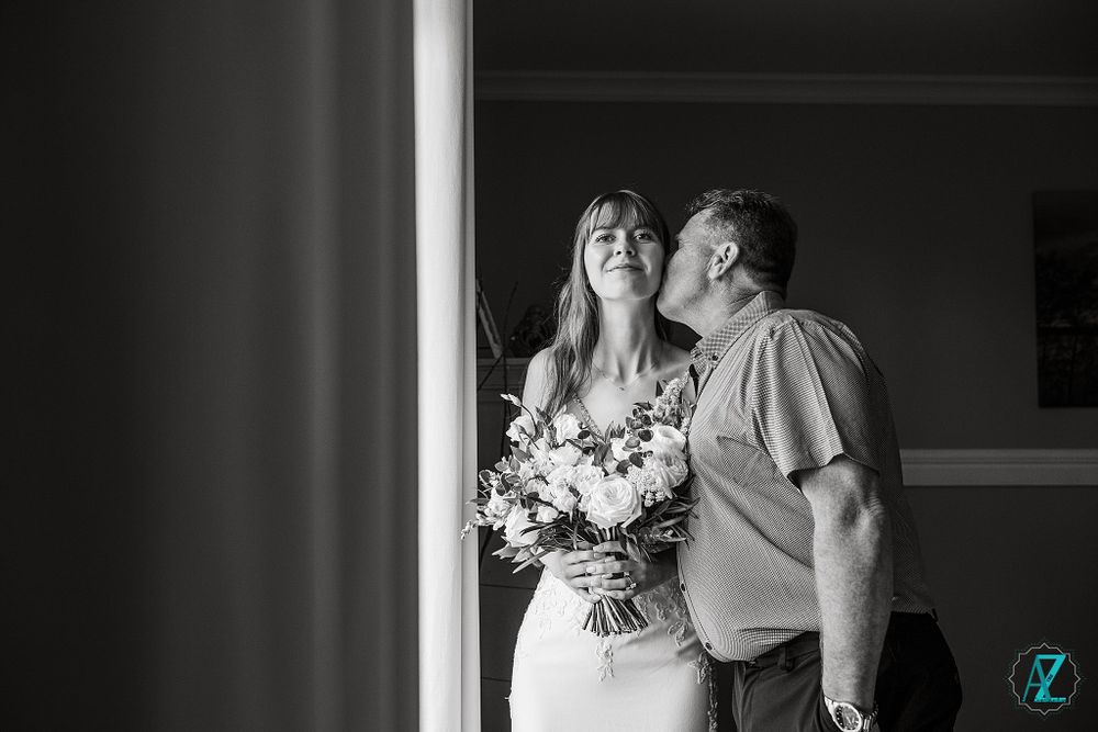 A tender black and white moment shared between loved ones on a wedding day.