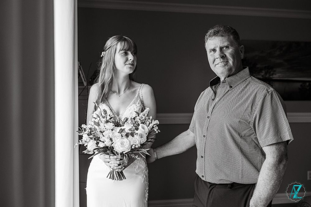 An intimate wedding day portrait near a window with a beautiful floral bouquet.