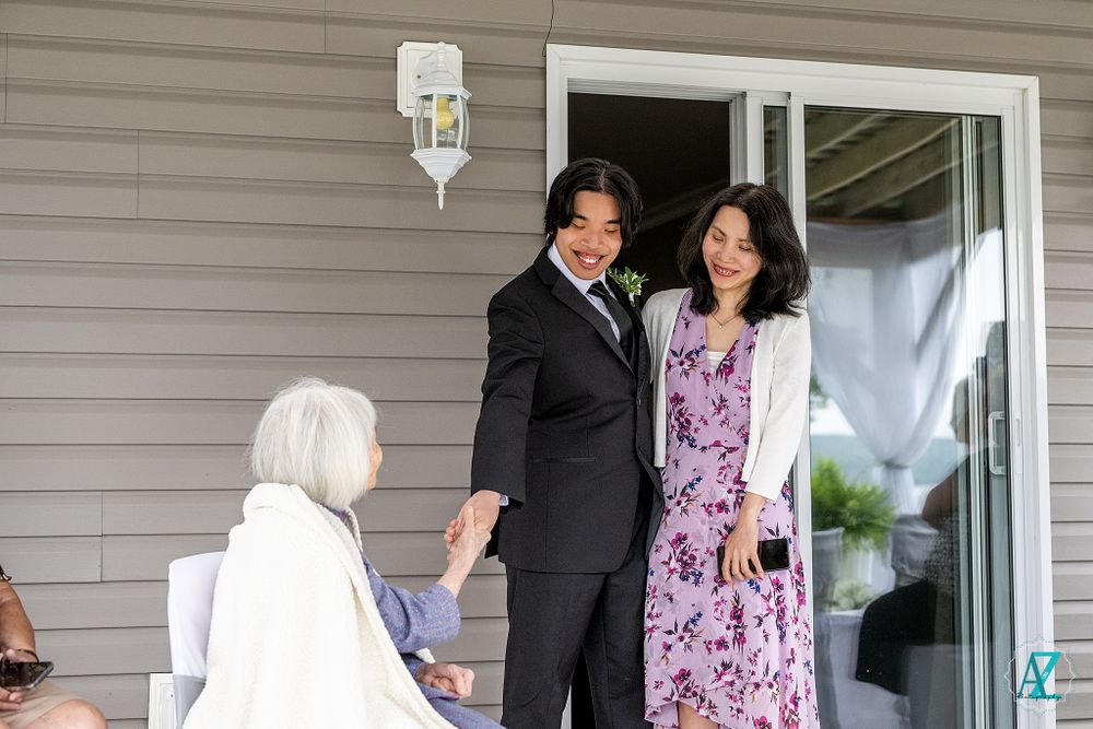 Two figures in formal attire standing during an outdoor wedding ceremony.