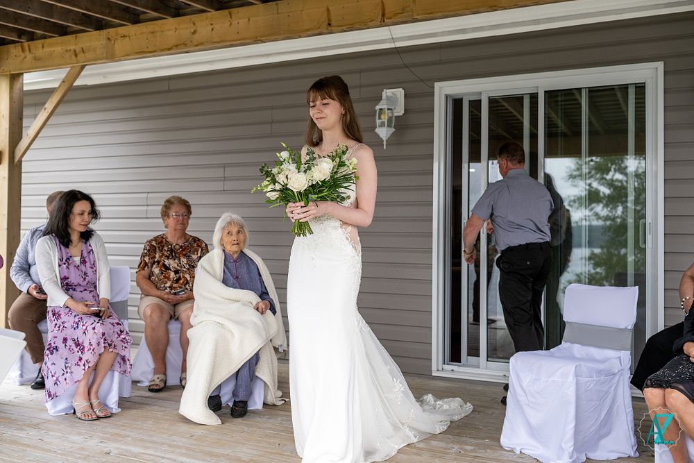 A candid moment captured in black and white during a wedding gathering on a porch.