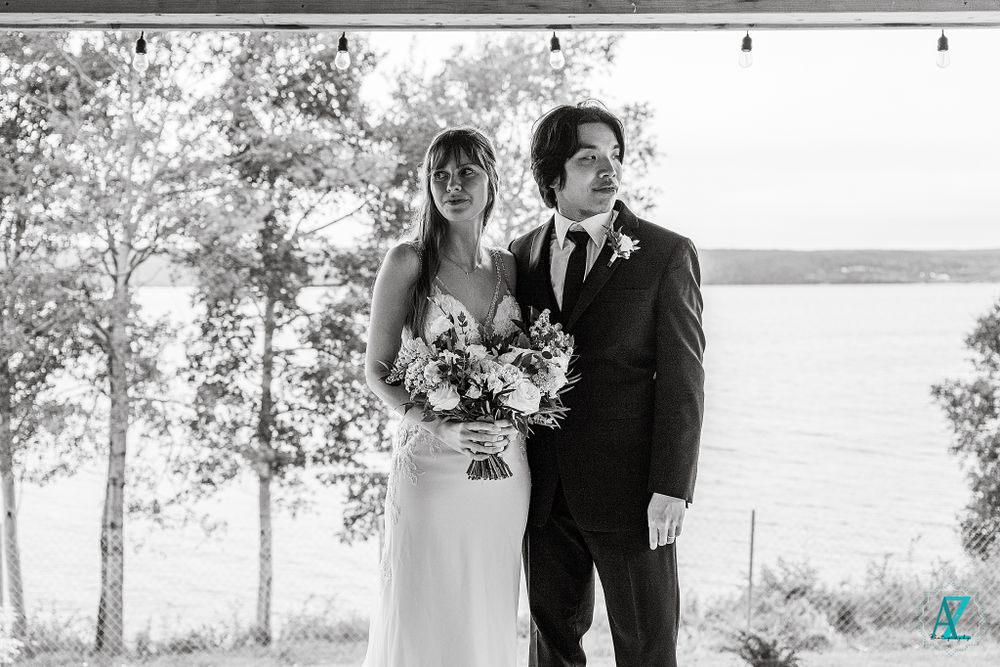 Wedding portrait with scenic lake and birch trees creating a natural backdrop.
