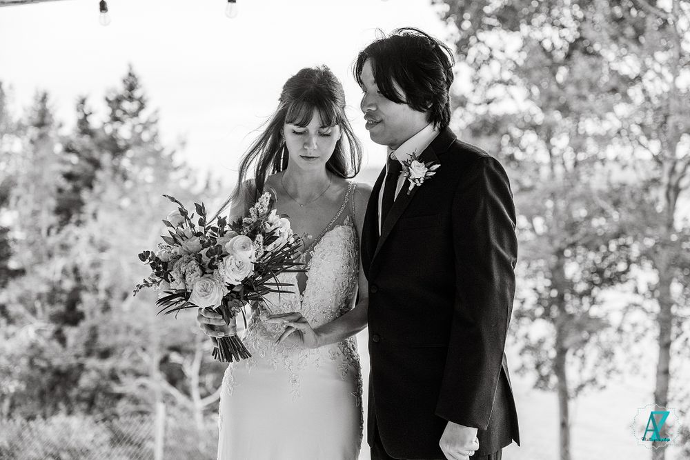 Intimate black and white wedding photo with elegant floral bouquet.