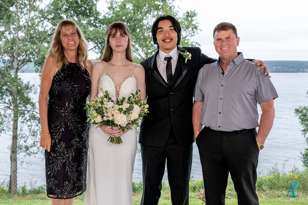 Outdoor wedding portrait of wedding party members by the lake with birch trees in background.