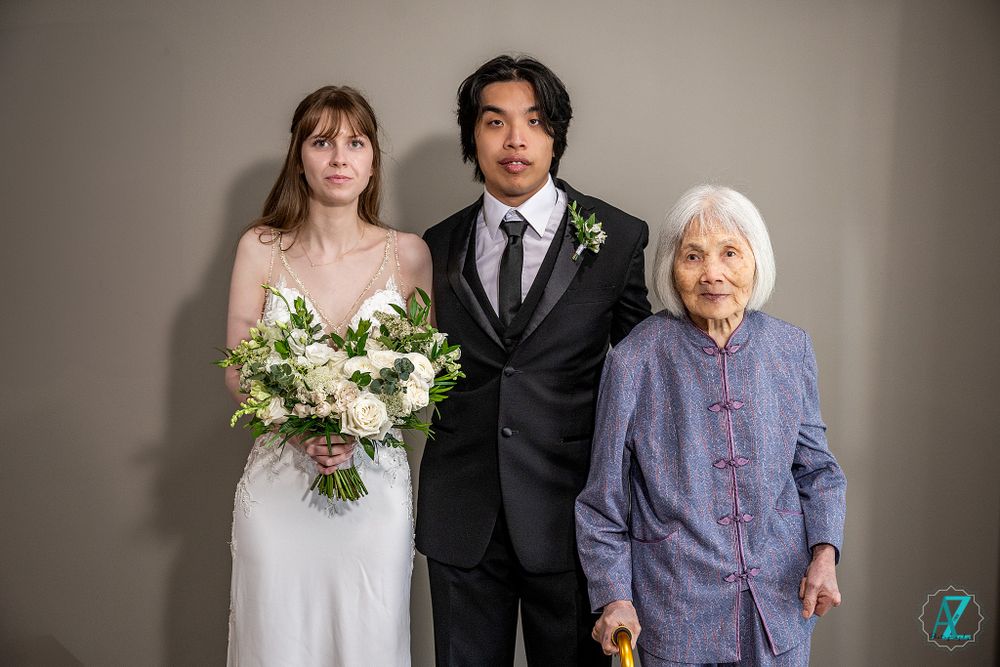 Indoor studio portrait of wedding party members against neutral background.