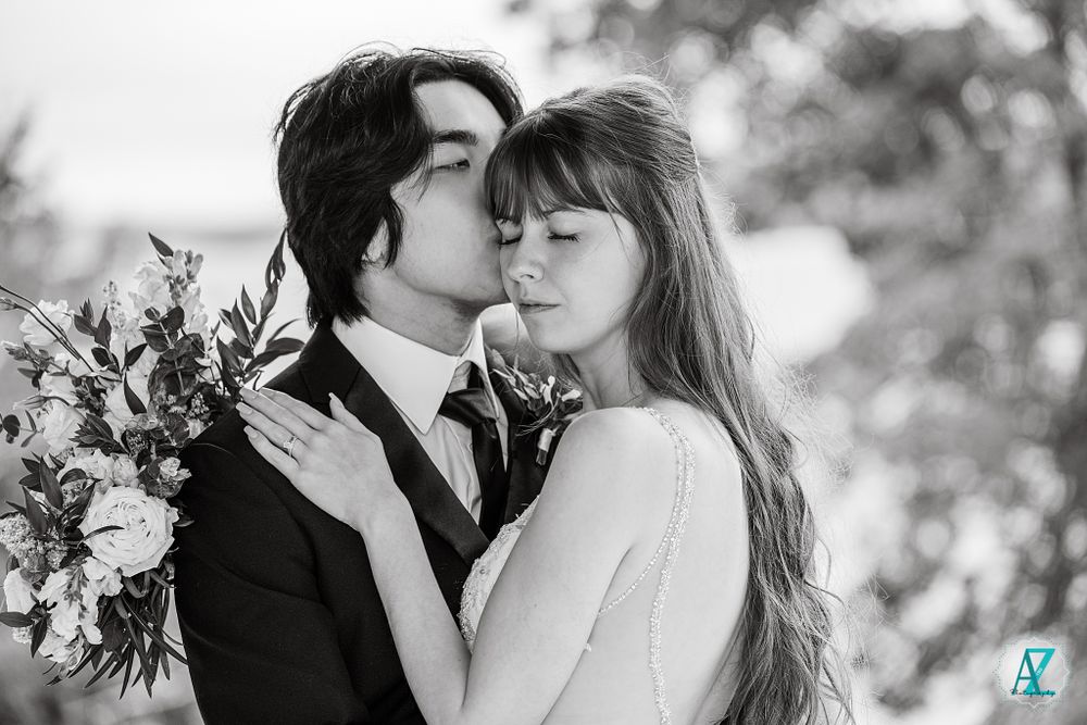 An intimate black and white portrait of newlyweds sharing a tender moment.
