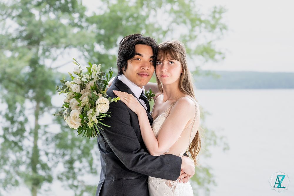 A romantic portrait of newlyweds embracing outdoors with a floral bouquet.