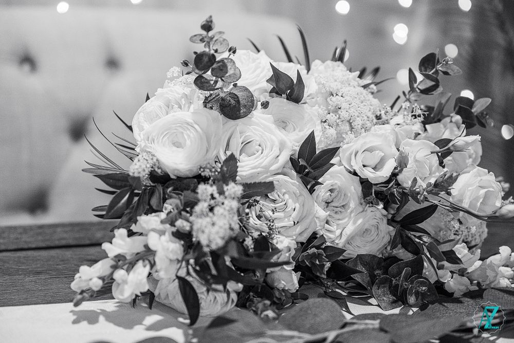 Black and white photo of elegant wedding bouquet with roses and mixed florals.