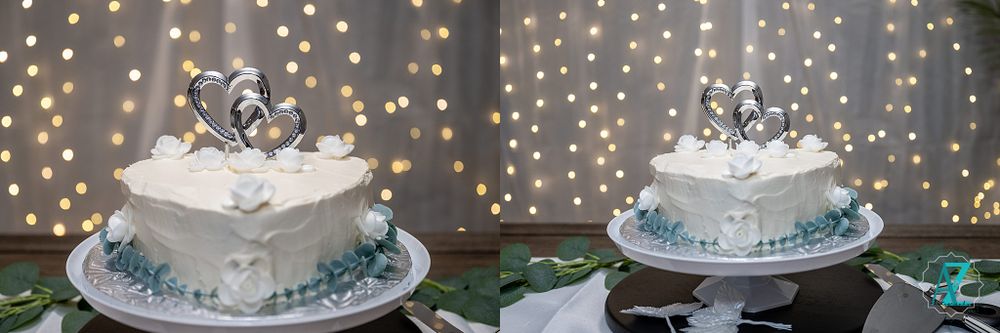 Two elegant white wedding cakes decorated with silver toppers and blue accents on display.