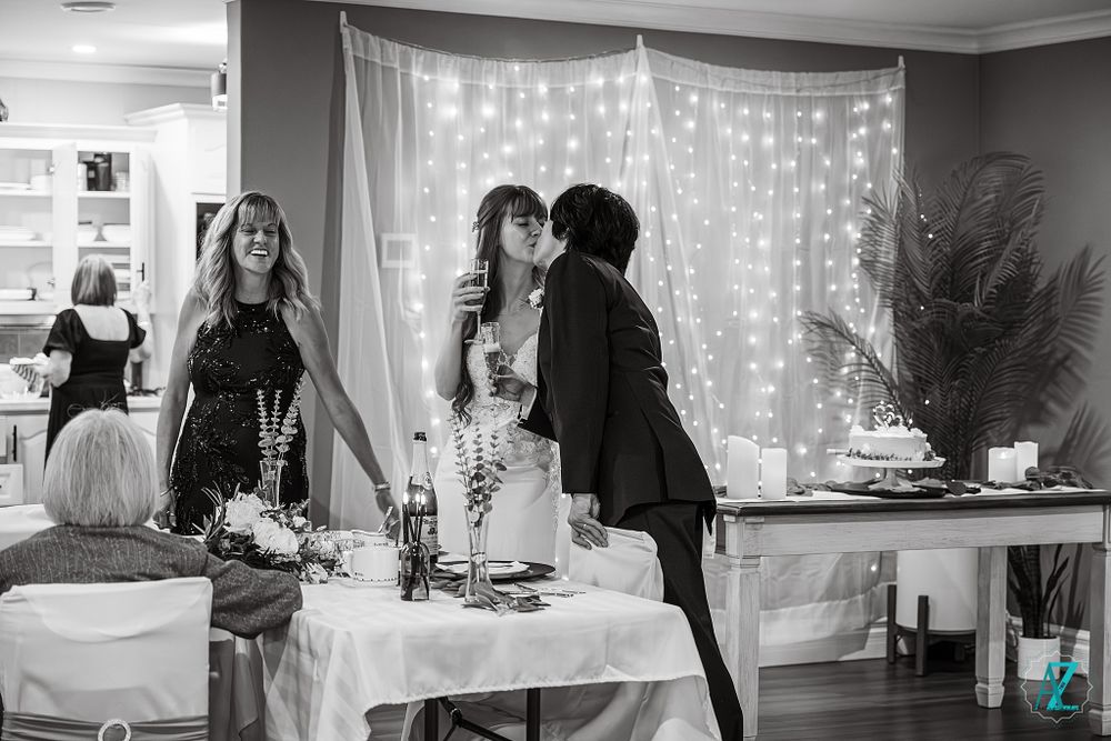 Black and white candid shot of a wedding reception cake cutting ceremony.