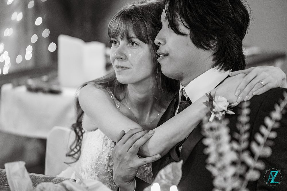Black and white intimate portrait of newlyweds sharing a tender moment at their reception.