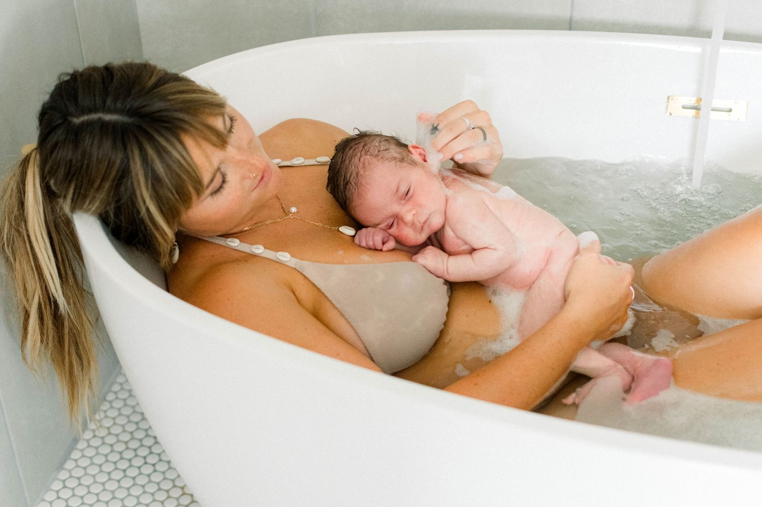 Tender moments captured during an indoor lifestyle newborn photography session.