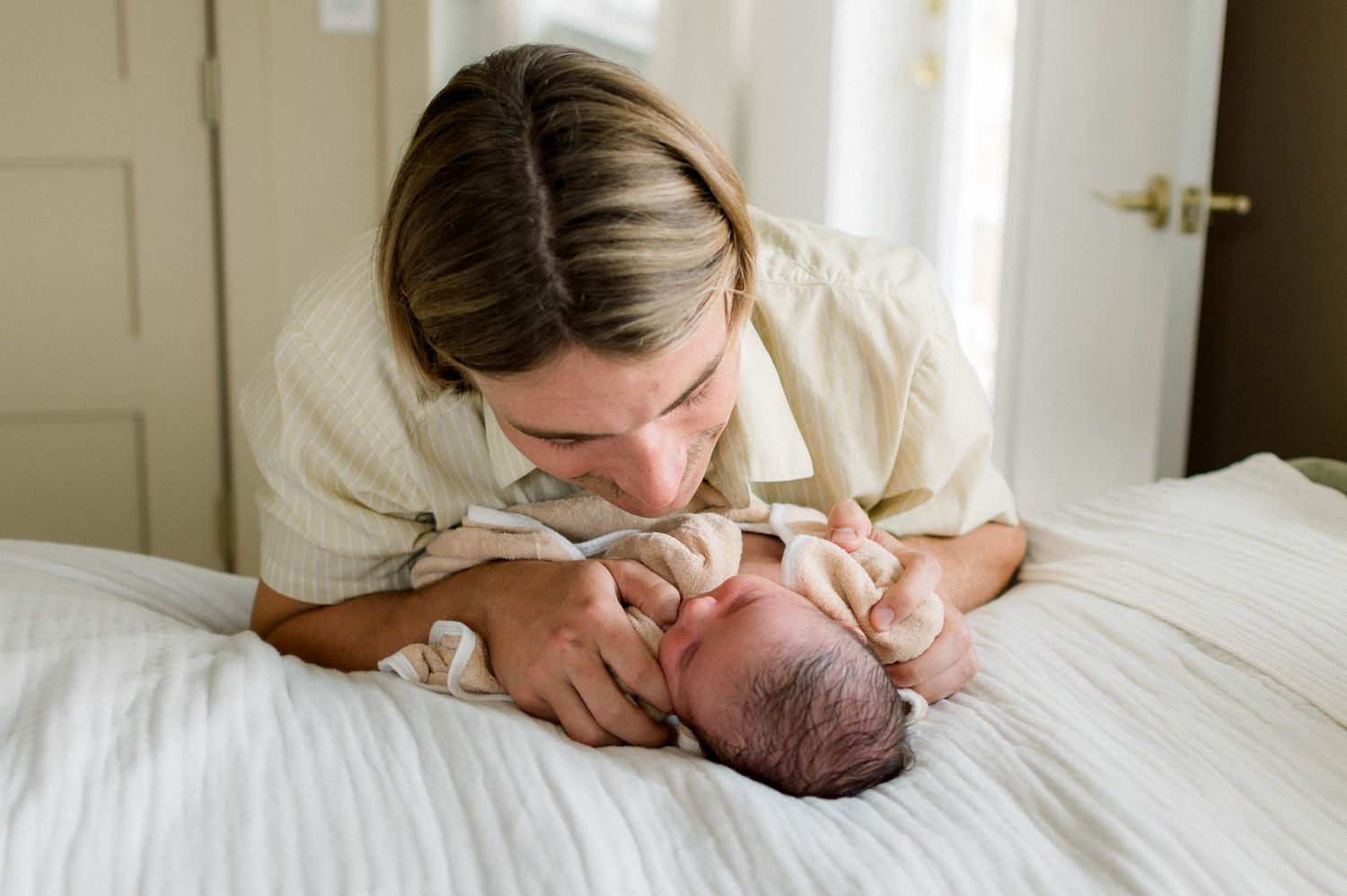 Natural light newborn photography session showing gentle bonding moments.