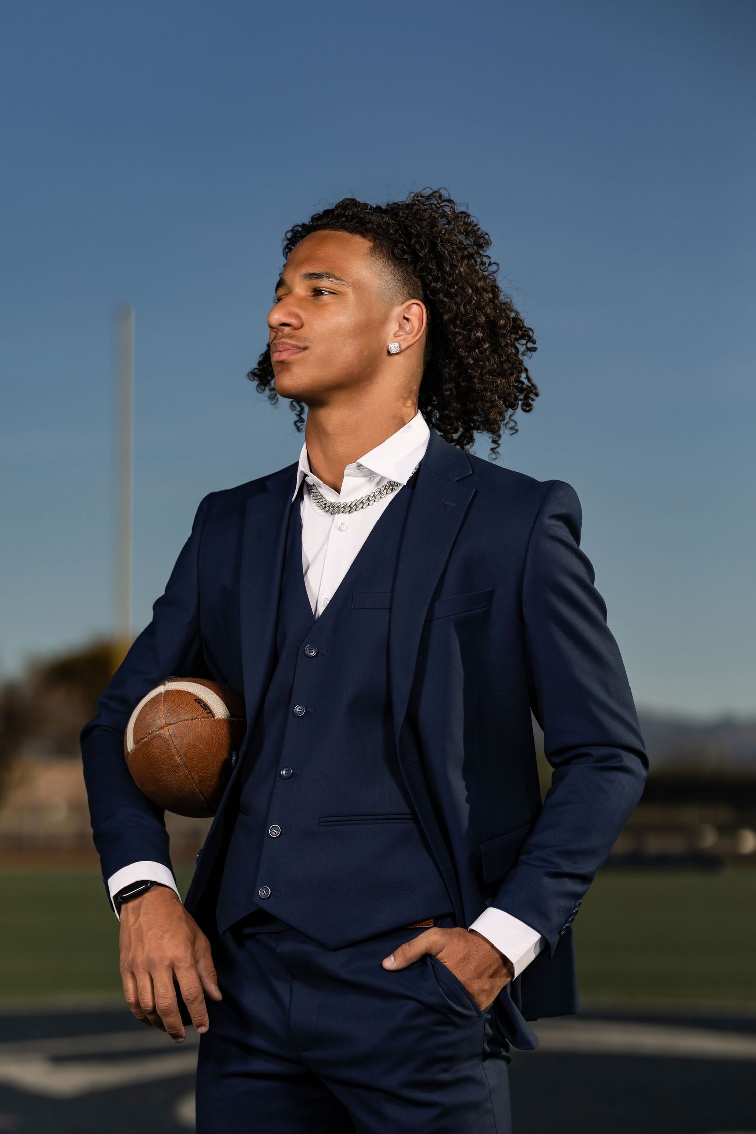 High school senior guy in a suit on a football field in Tucson, photographed by Tucson Senior Photographer