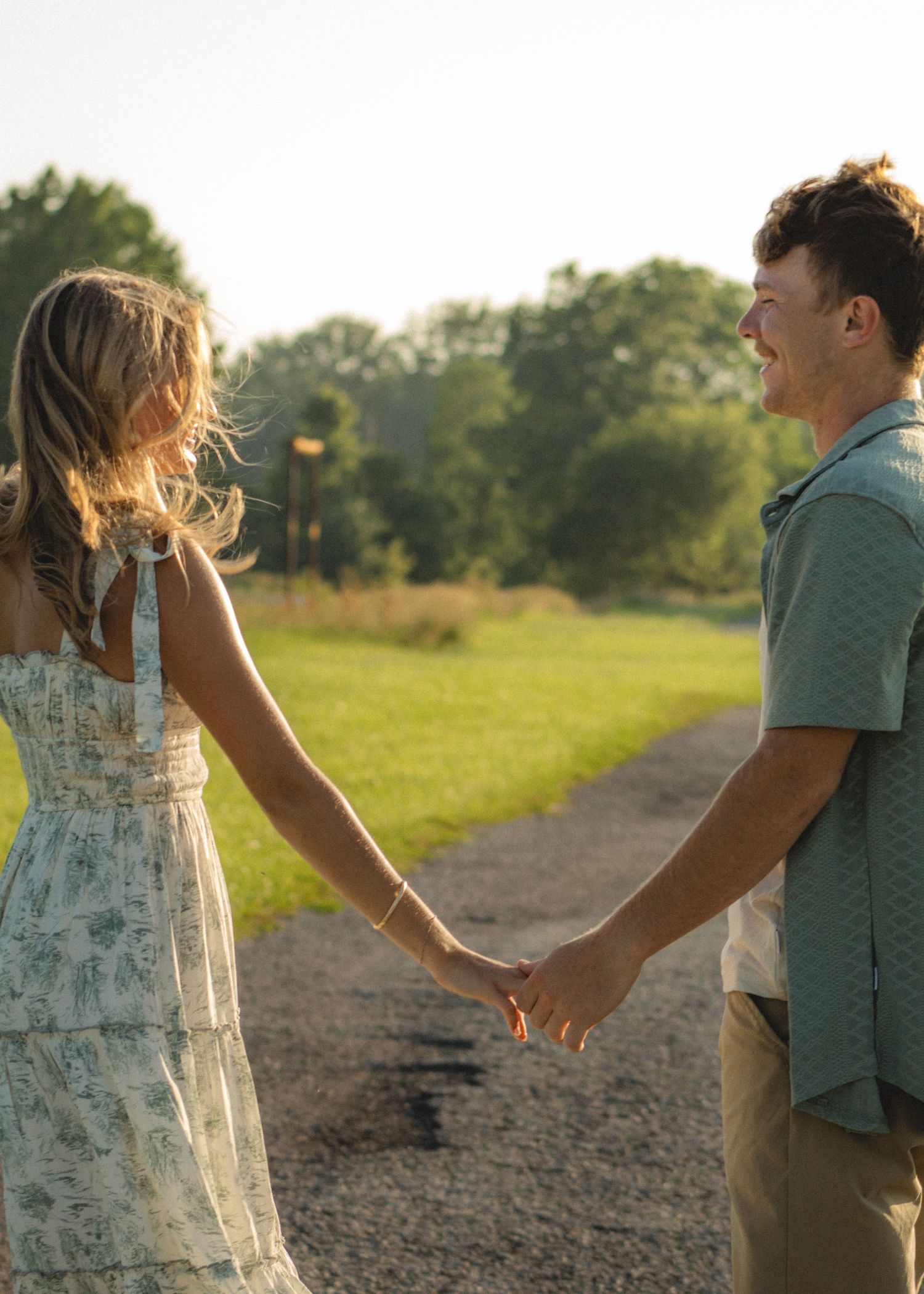 a couple holding hands in a bright and airy park