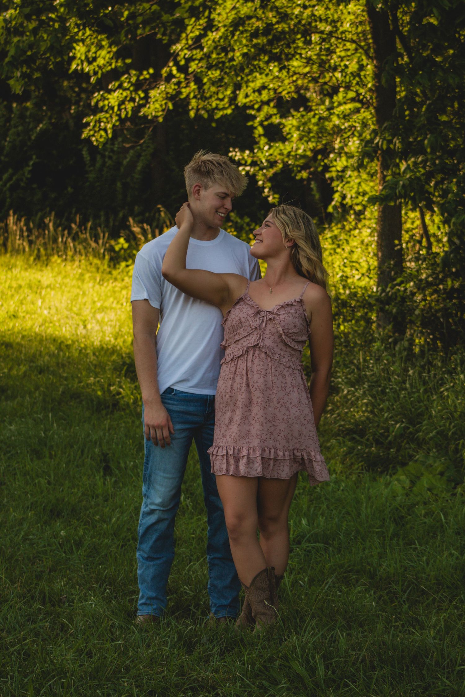 a couple posing in a green wooded park