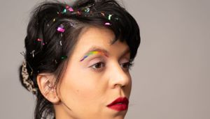 A series of portraits with floral hair accessories against a gray backdrop.
