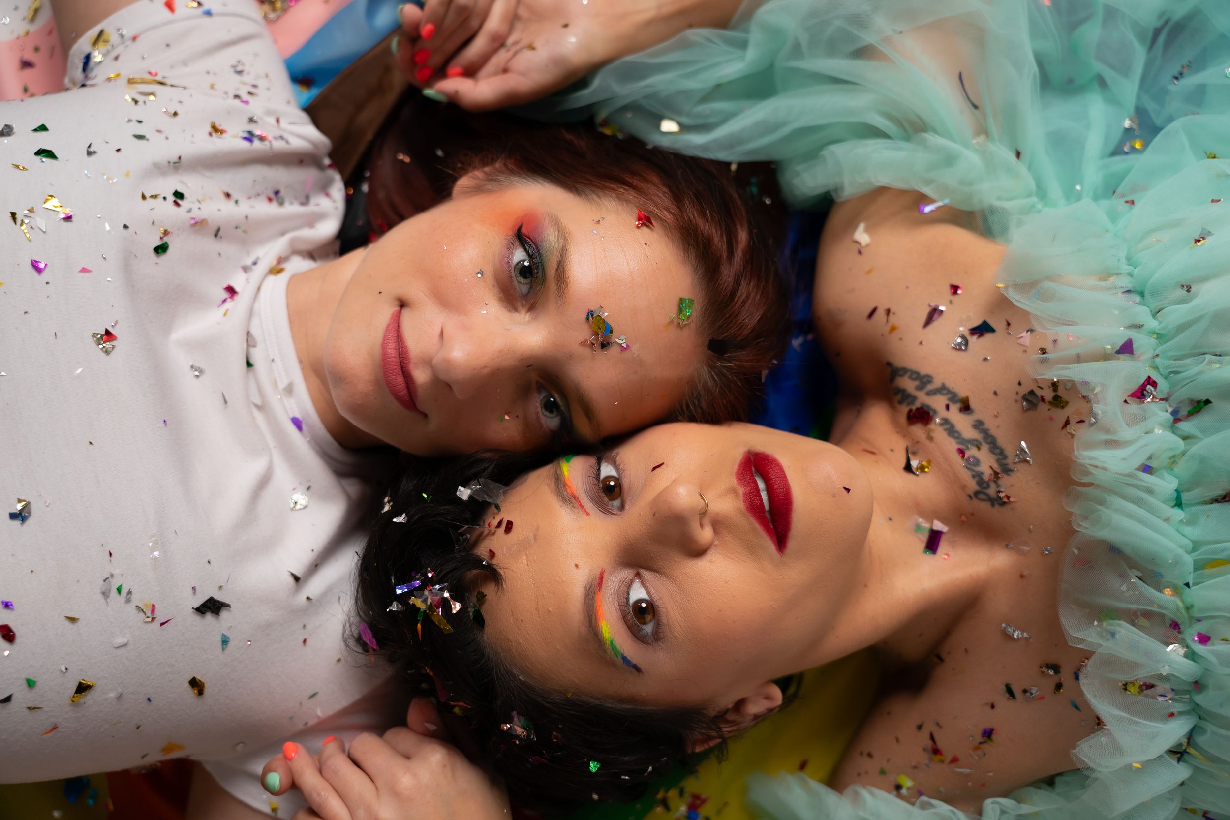 Artistic portrait series with glitter confetti and mint green tulle dress creating dreamy atmosphere.