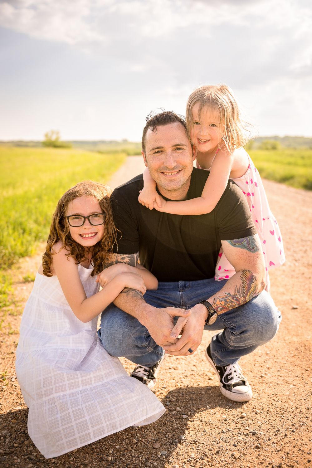 Family portrait session on dirt road during golden hour.