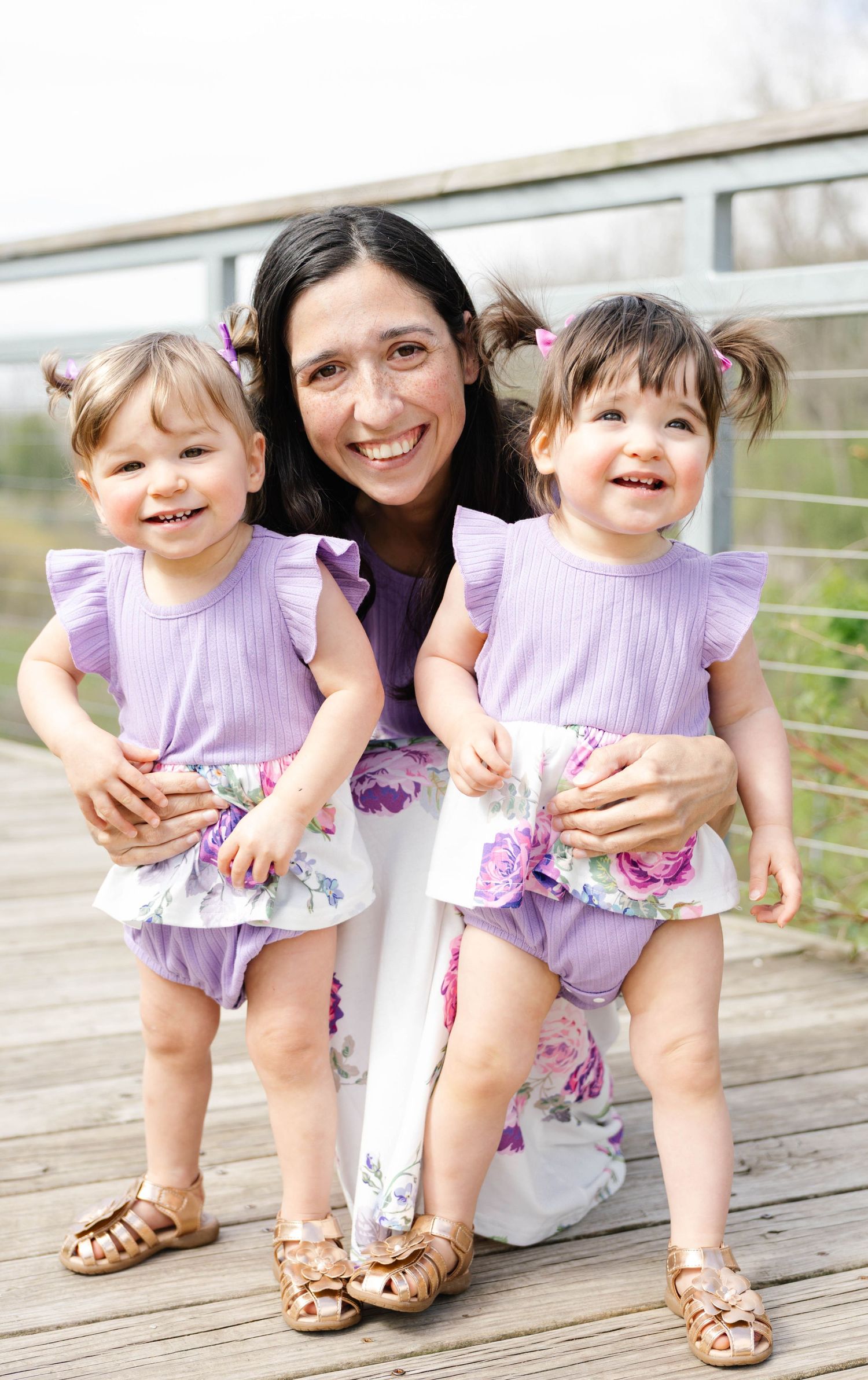Baby wearing pink tulle dress with polka dots and gold 'ONE' text for first birthday celebration.