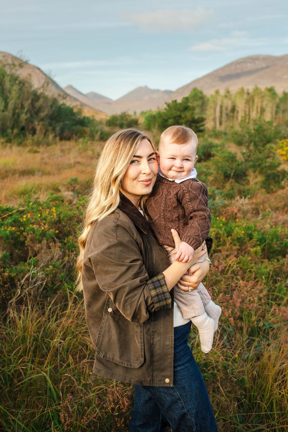 Family enjoying an autumn day in the mountains with scenic rolling hills and golden grass in the background.