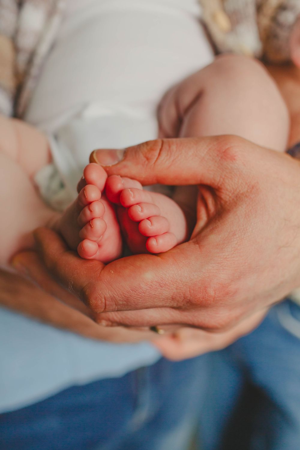 A series of close-up photos showing tiny baby feet being gently cradled in adult hands.