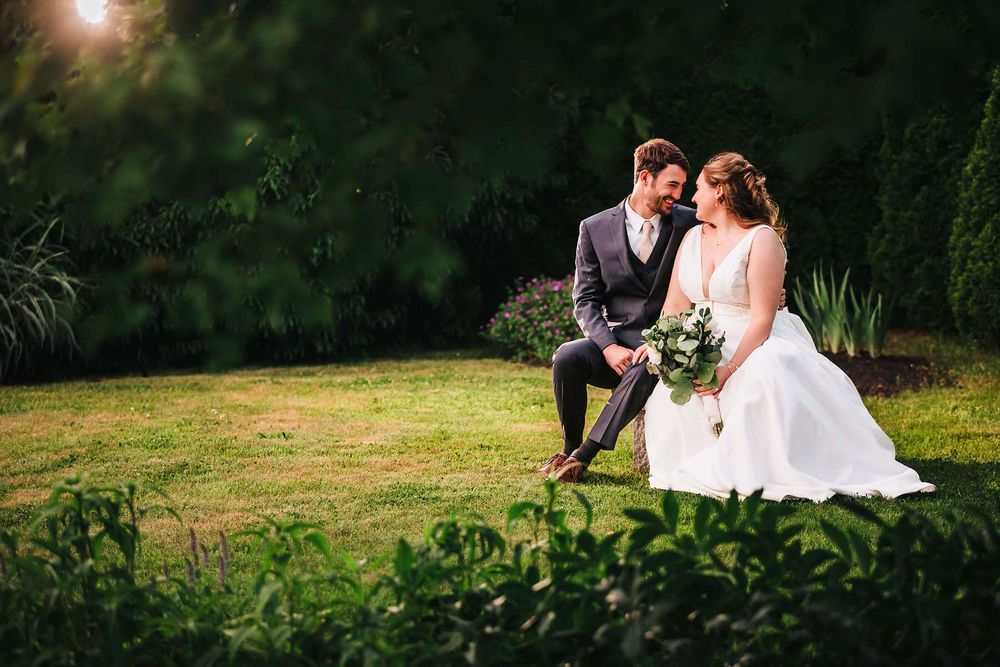 The bride and groom share a joyous living moment during a candid portrait at sunset in the Boston Public Garden