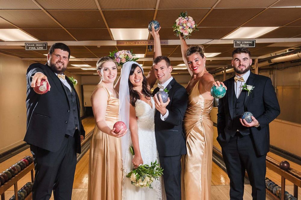 The entire bridal party gather in the bowling alley of the Winthrop Yacht Club for a fun portrait