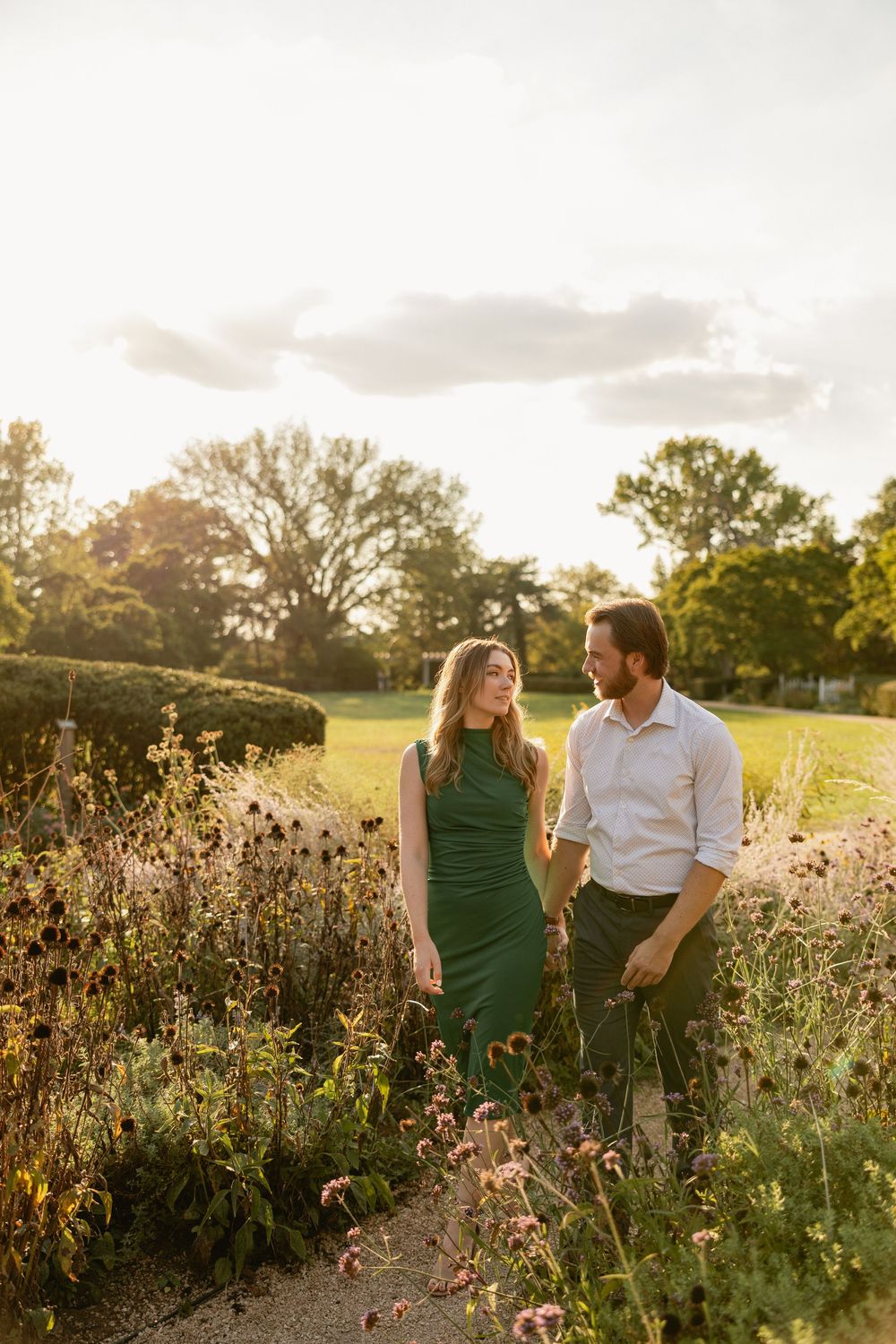 Couple shares tender moments in a wildflower field during golden hour sunset.