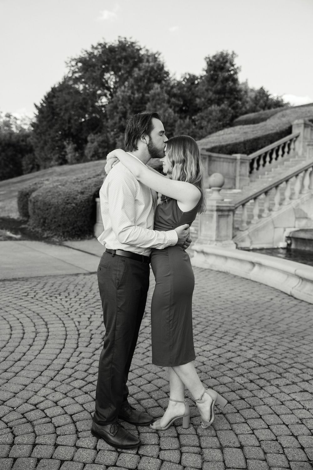 Black and white sequence of a couple dancing together on a cobblestone path beside stone steps.