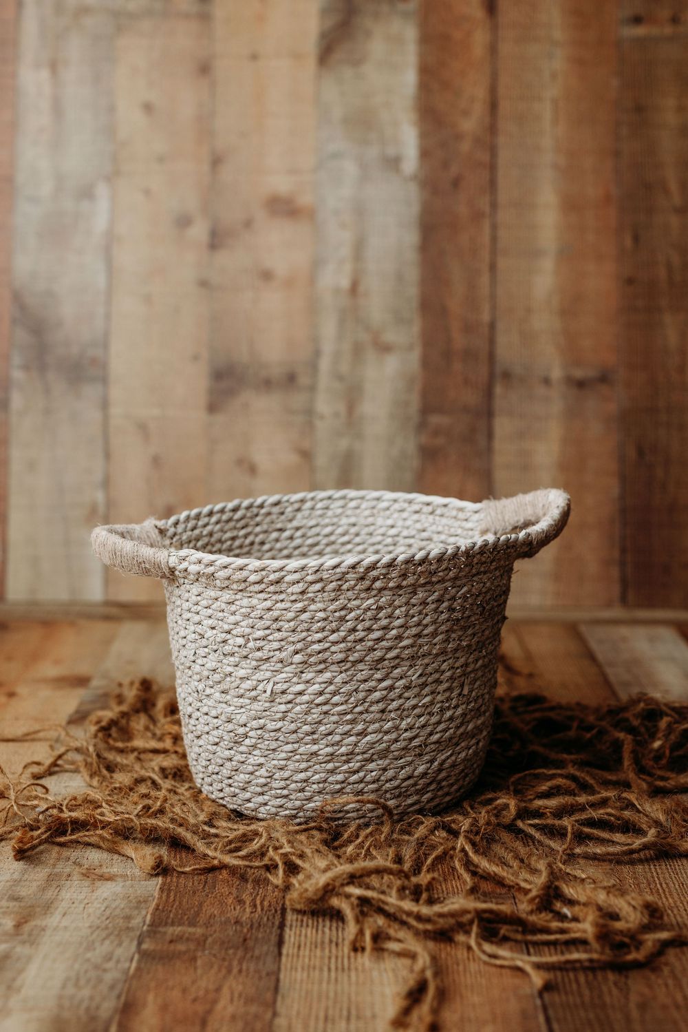 Four sequential photos of a beige woven rope basket on wooden surface with scattered wood shavings.