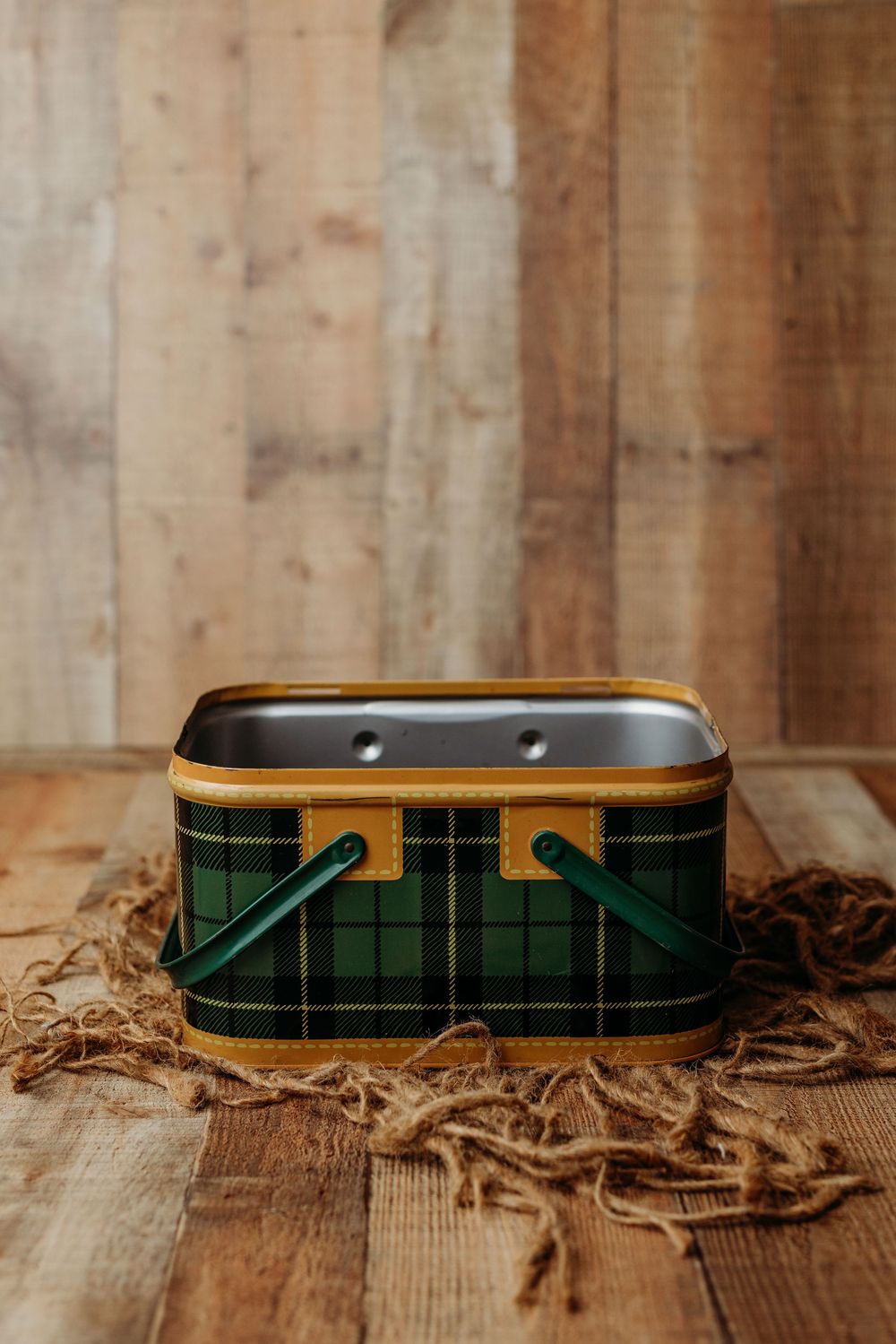 Four sequential photos showing a dark green and gold tin container lying on rustic wooden surface with wood shavings.