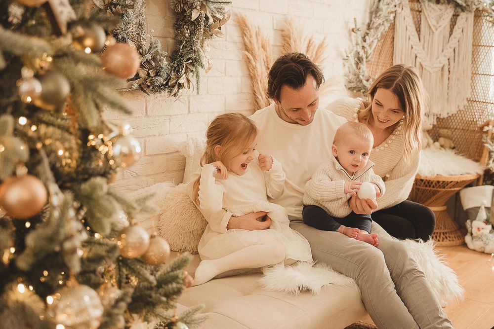 Family enjoying festive moments together in a cozy Christmas setting with decorated trees and ornaments.