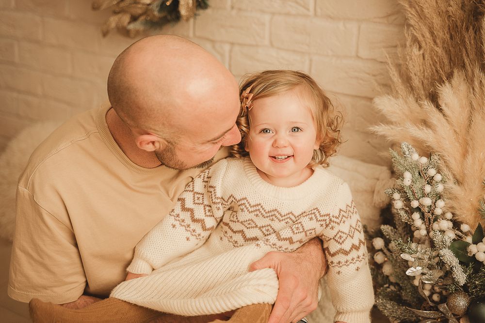 A series of warm-toned photographs showing tender moments between siblings in cream-colored knitwear with floral accents.