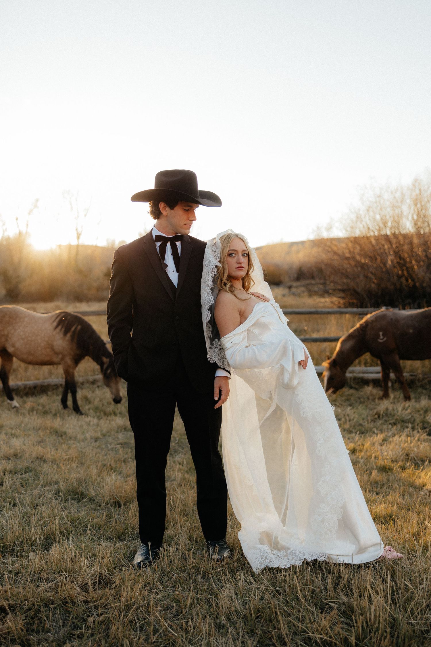 A romantic wedding couple in the Montana mountains surrounded by horses. Near Bozeman, Montana.
