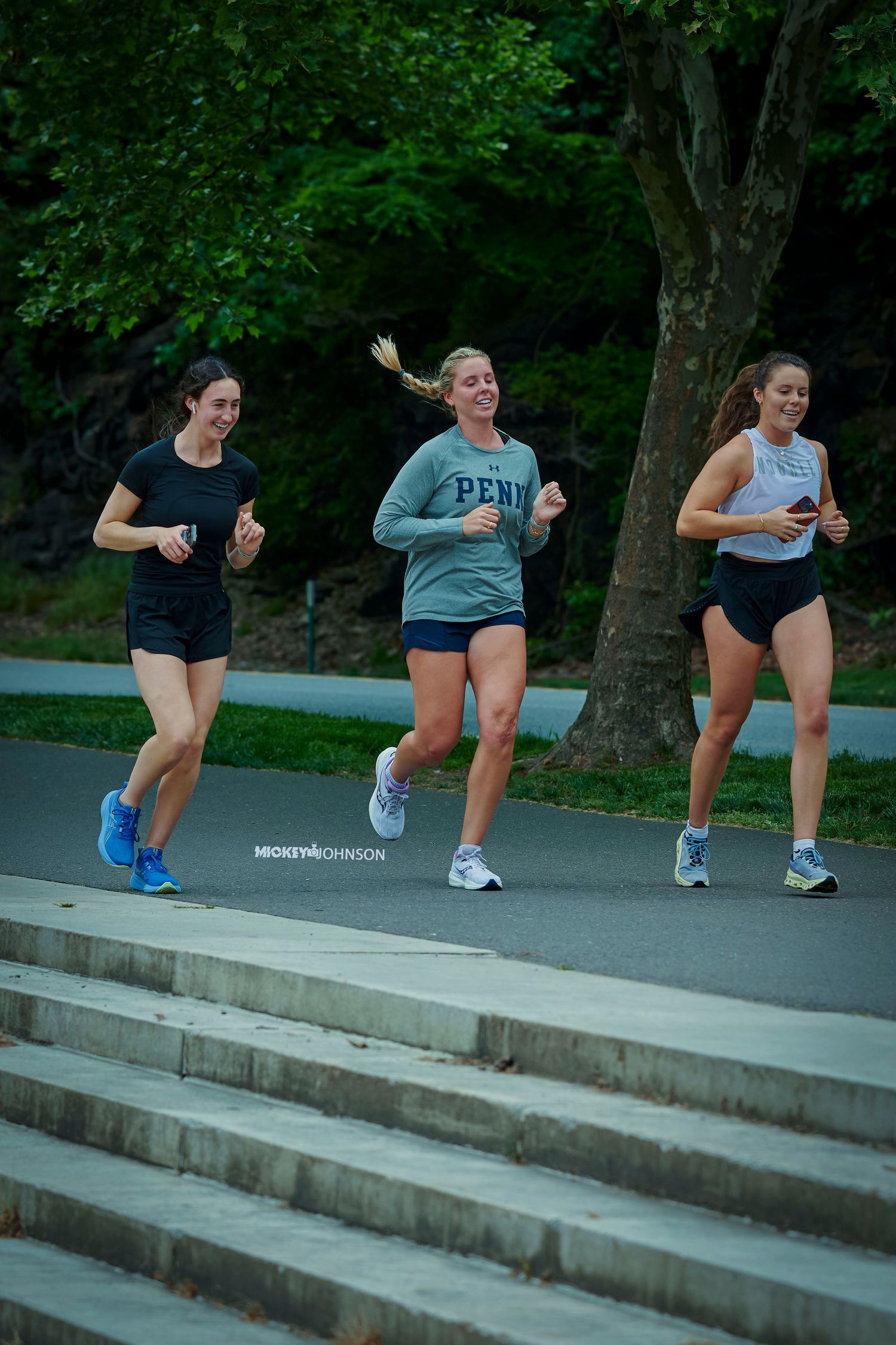 People exercising and jumping on concrete steps outdoors in an energetic workout session.