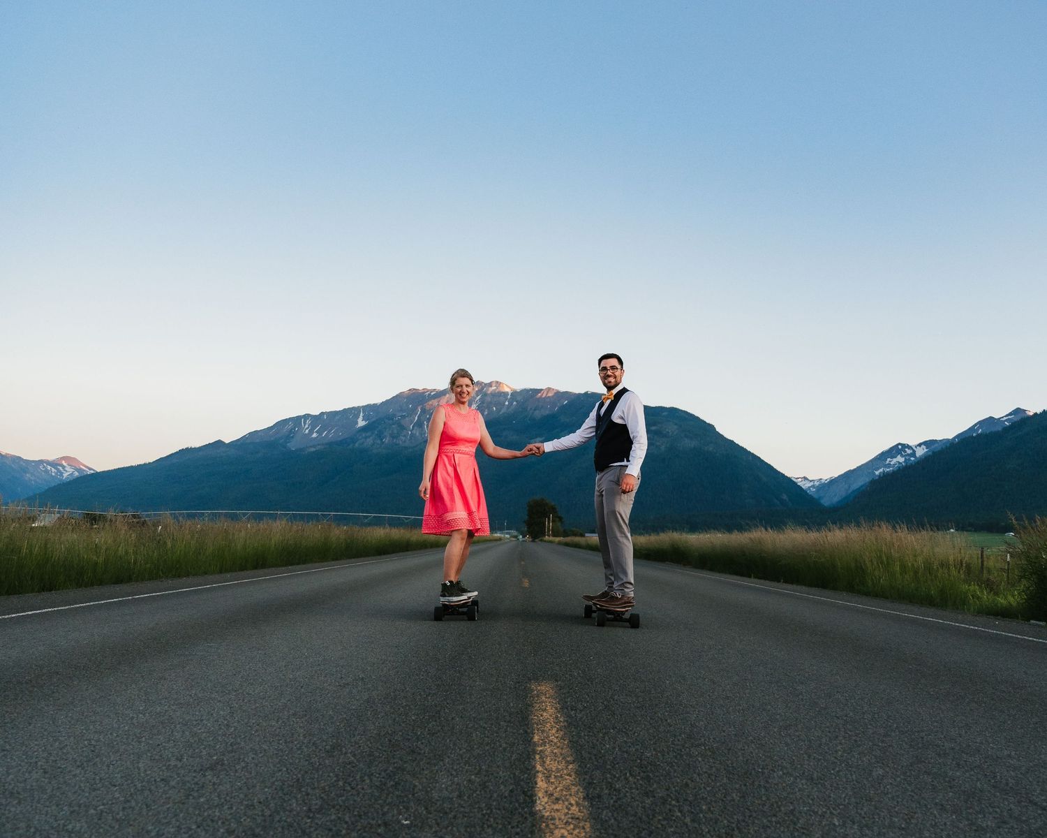 Couple dances on empty mountain road during blue hour.