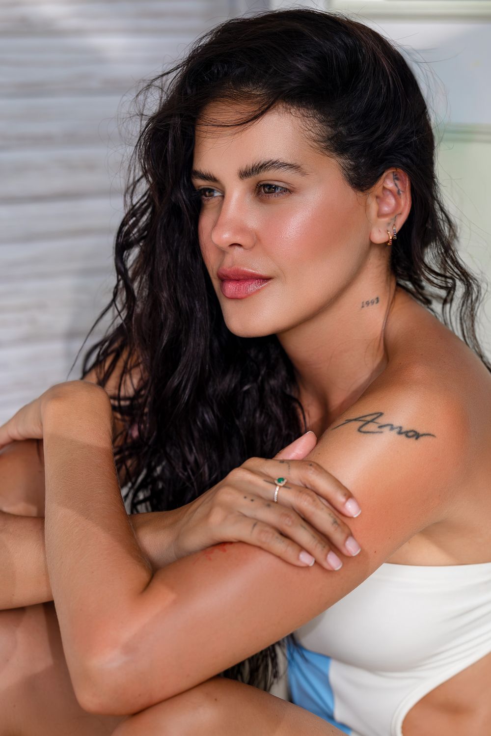 A photo series shows close-up shots of a person with dark hair in a white top posing seductively against a light background.
