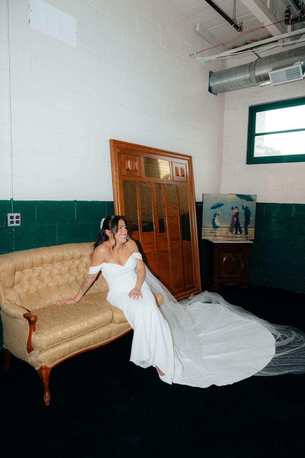 Artistic bridal portraits on vintage couch in minimalist white room setting.