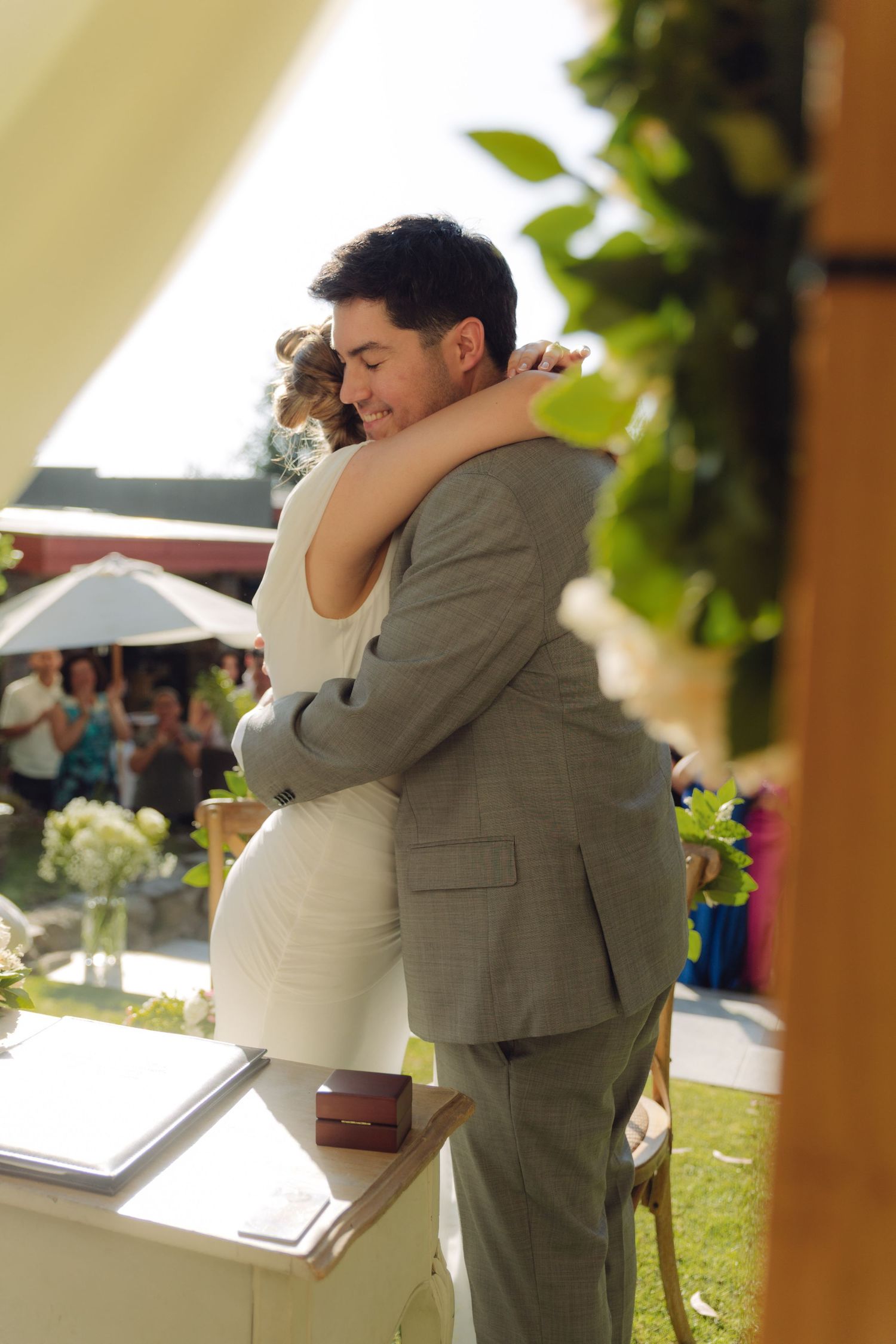 Bride and groom share an emotional hug at their outdoor wedding ceremony.