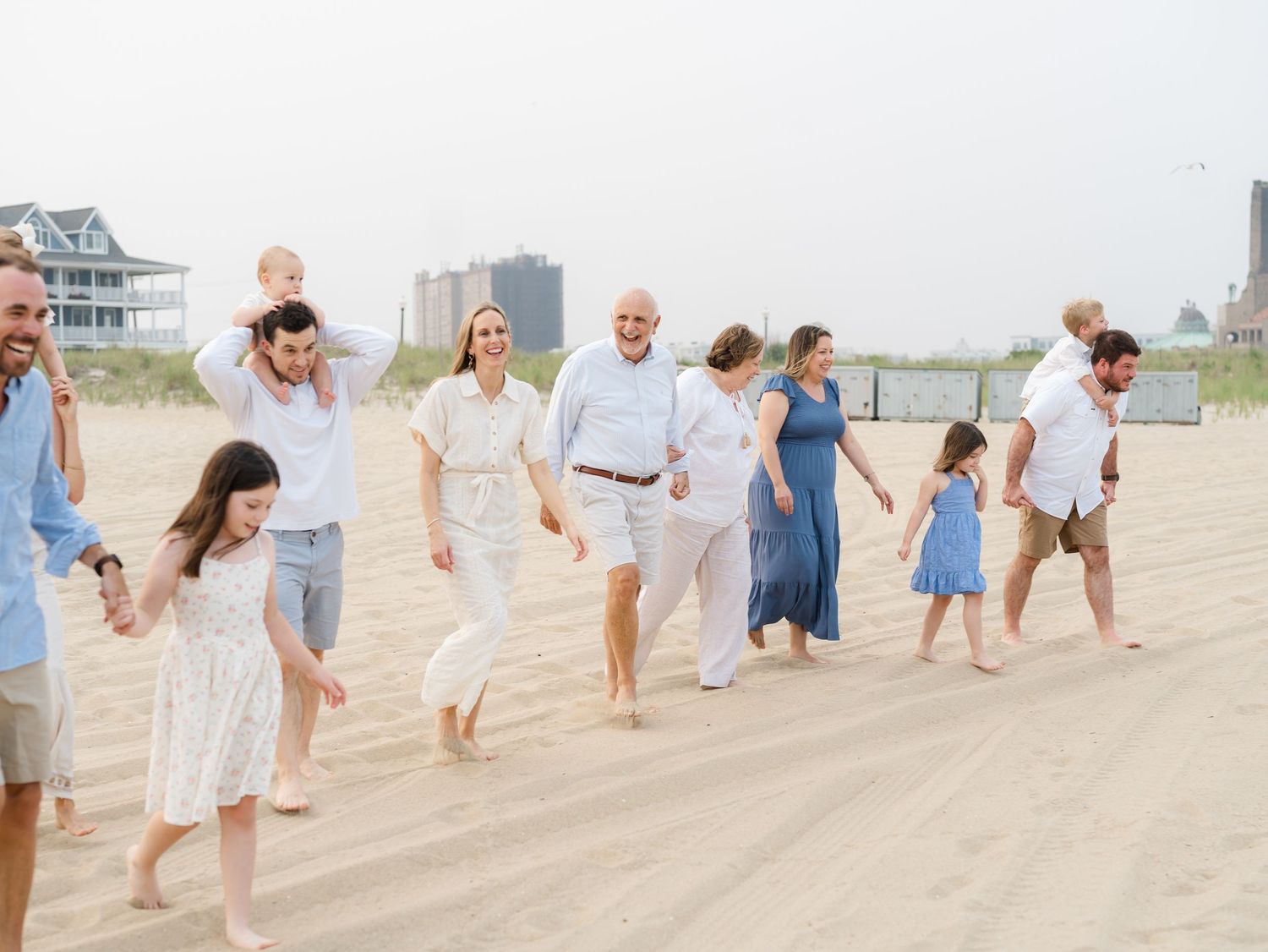 Family wearing soft blue, linen, and cream outfits coordinated for a Jersey Shore beach session.