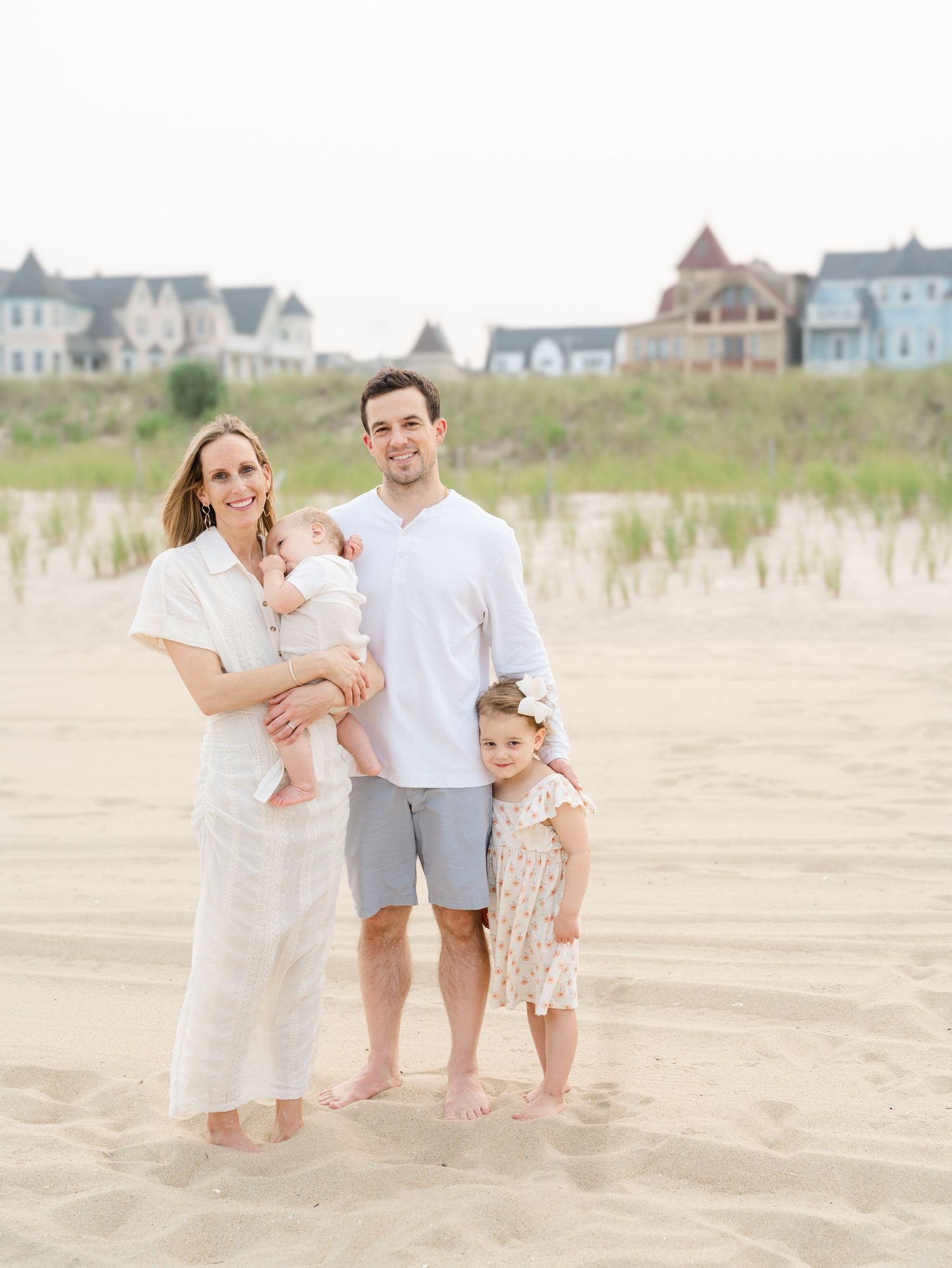 Parents holding their young children while walking along the water's edge in Ocean Grove NJ.