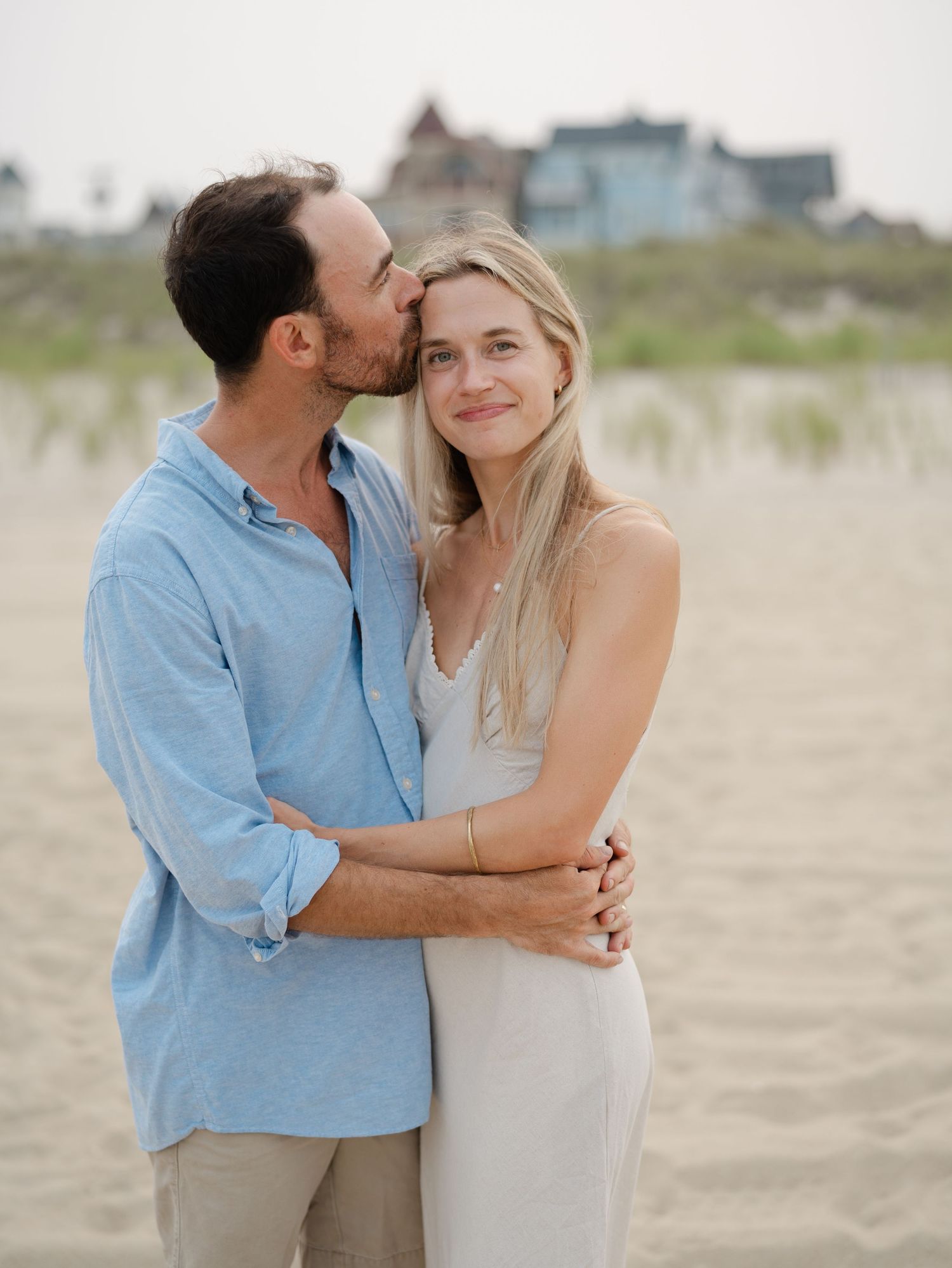 Husband and wife embracing on the beach during golden hour in Ocean Grove New Jersey.