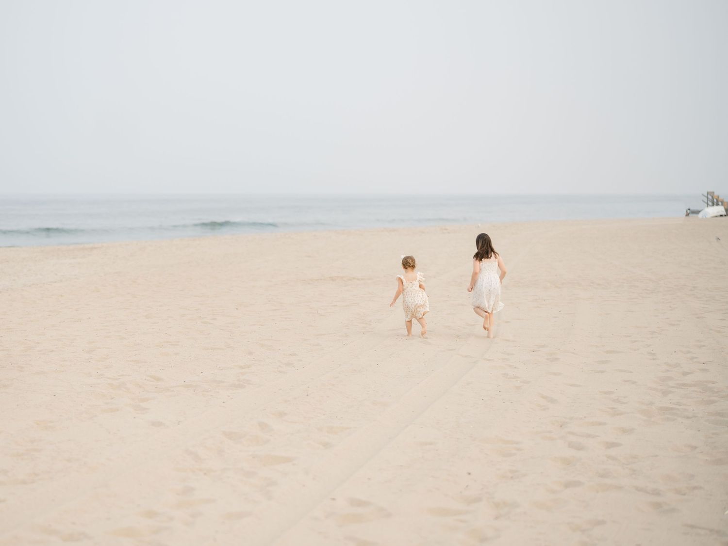 children run down to the ocean together.