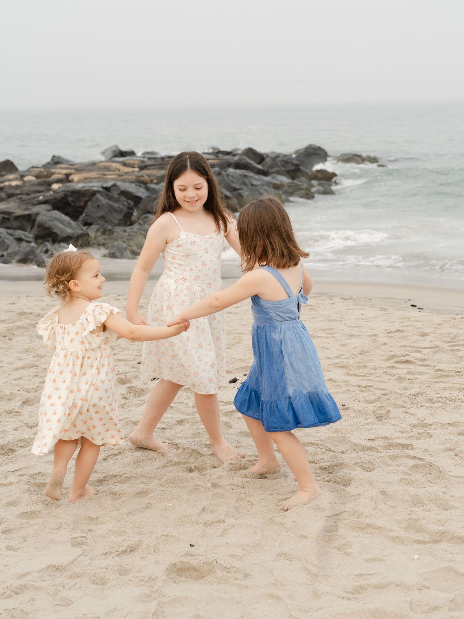 Young children playing along the water's edge on Ocean Grove beach during a sunset photo shoot.