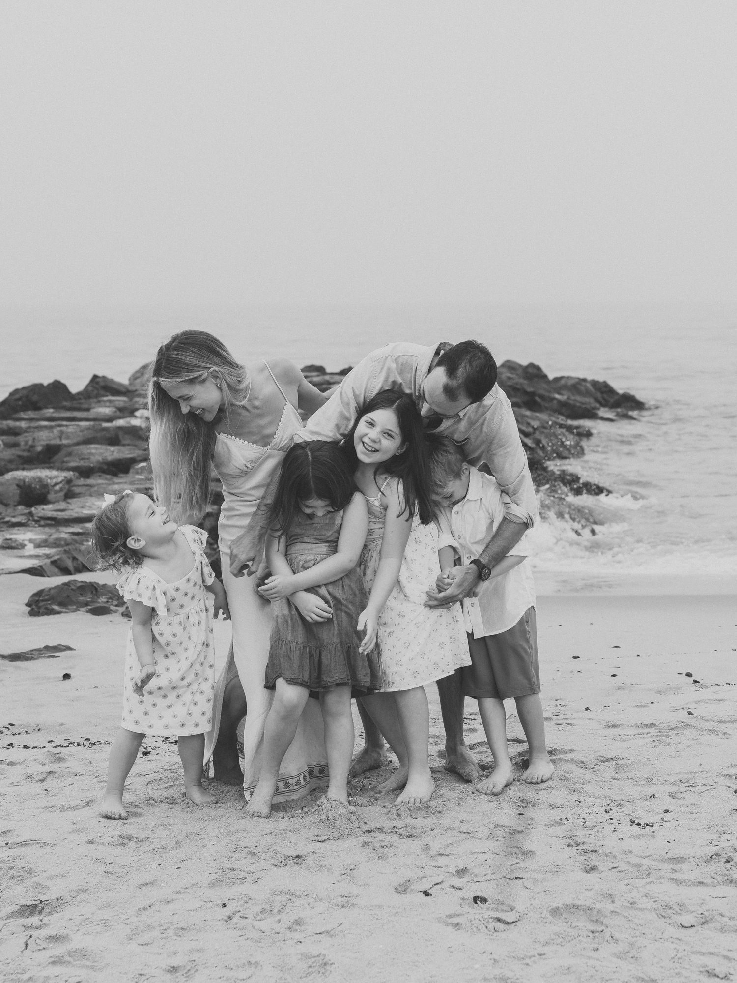 Aunt and uncle gathered near the ocean on a summer evening in Ocean Grove NJ playing with their nieces and nephews.