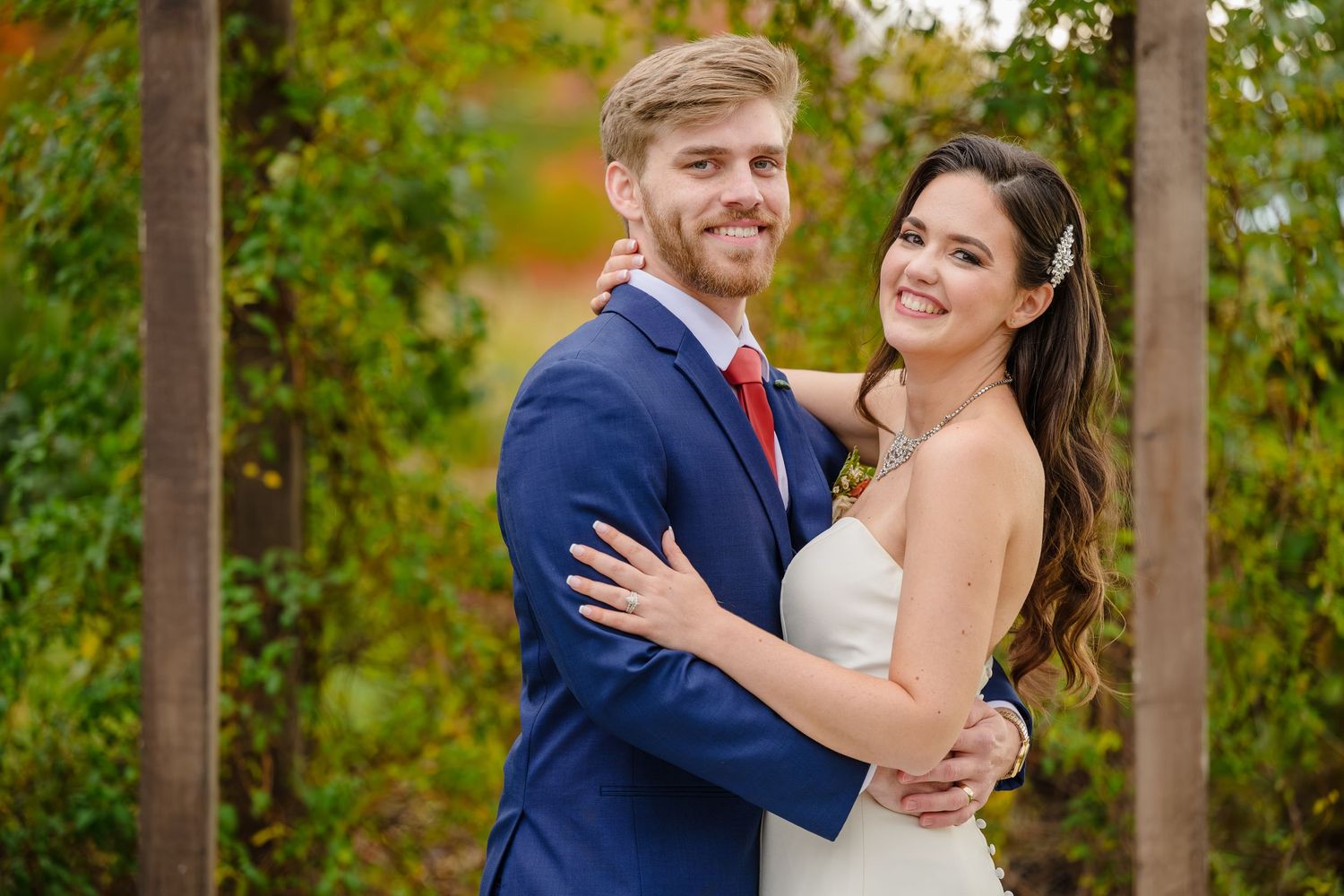 Bride and Groom standing in front of arch outside in October after their wedding ceremony at Running Horse Farm in Geneva Ohio