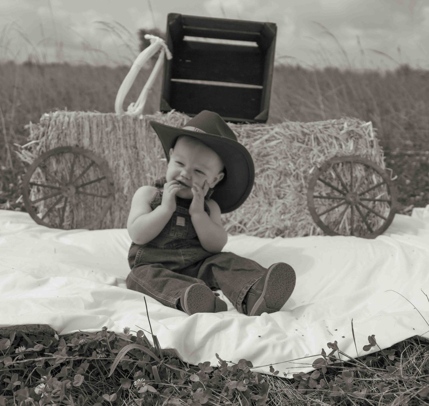 Central PA first birthday photography session featuring a little cowboy celebrating with a western-themed cake smash, cowboy hat, and boots.