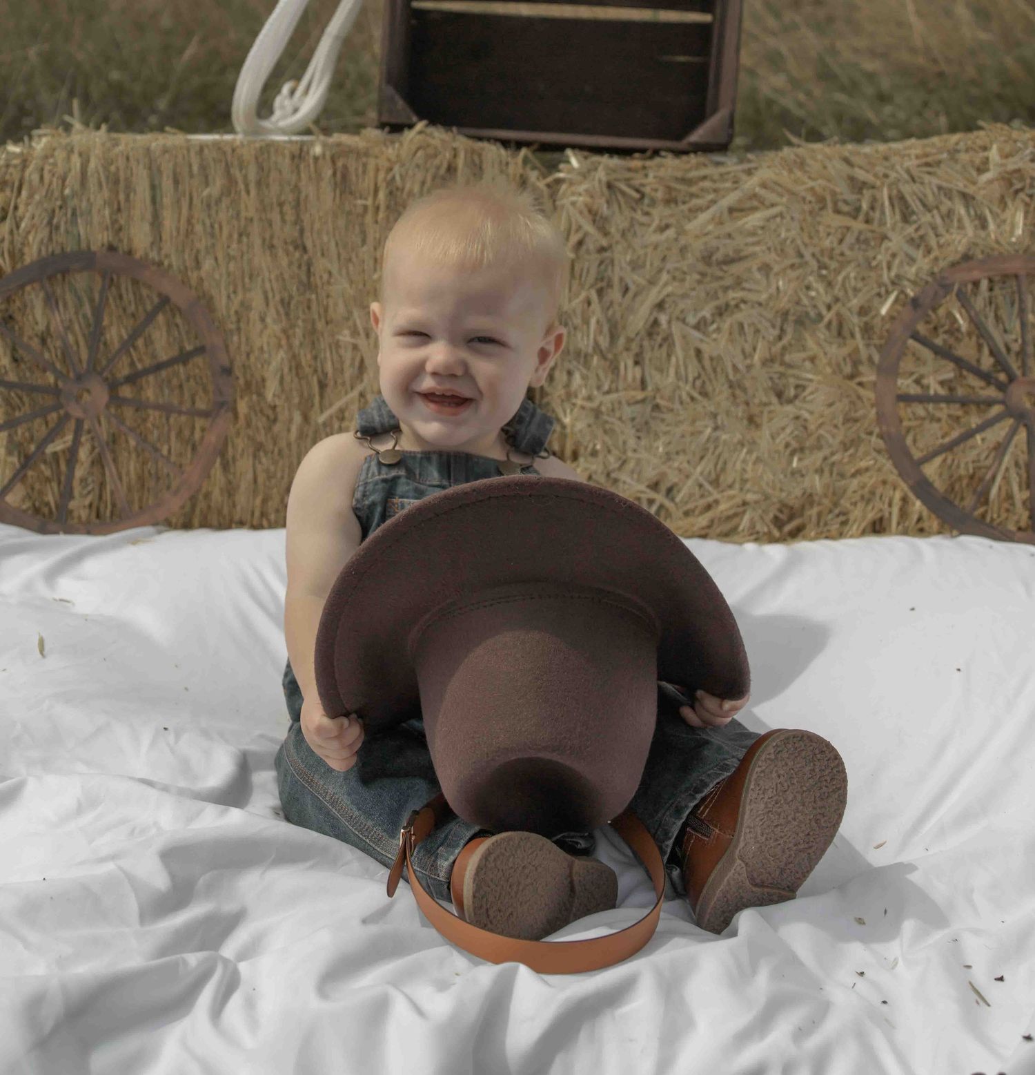Central PA first birthday photography session featuring a little cowboy celebrating with a western-themed cake smash, cowboy hat, and boots.
