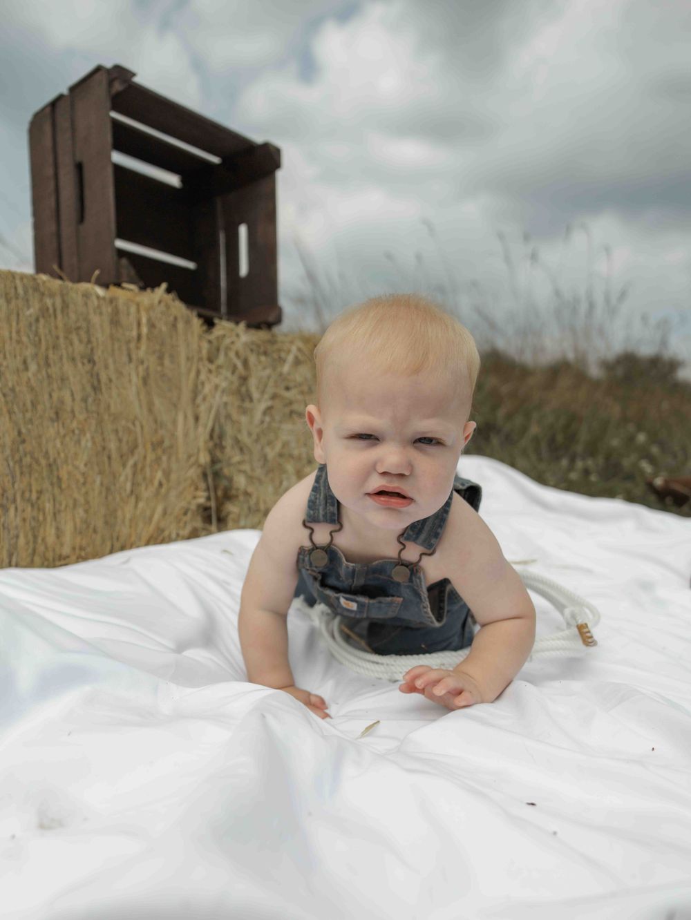 Central PA first birthday photography session featuring a little cowboy celebrating with a western-themed cake smash, cowboy hat, and boots.